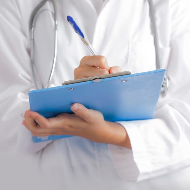 Médico escribiendo en una carpeta azul